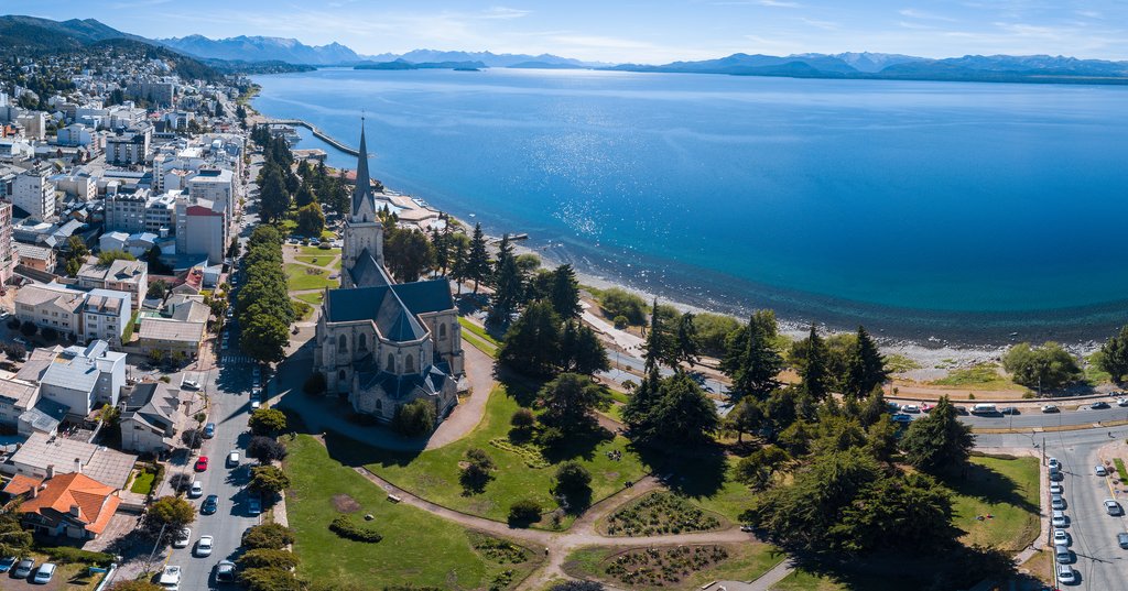 Fotografía de un paisaje montañoso nevado entre Puerto Montt y Bariloche, con lagos y bosques en el fondo.