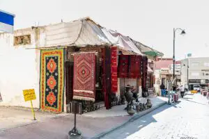 Imagen de una tienda en un mercado jordano, con una variedad de artesanías tradicionales, joyas y textiles expuestos.