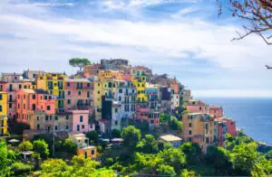 Fotografía de las coloridas casas de Cinque Terre rodeadas de viñedos en una tarde de verano.